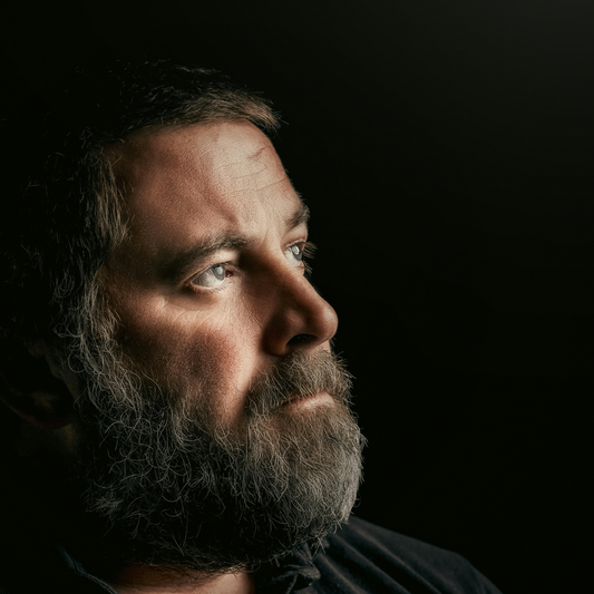 Portrait of a man in shadow symbolizing depression, mental health struggle, and the importance of supportive words.