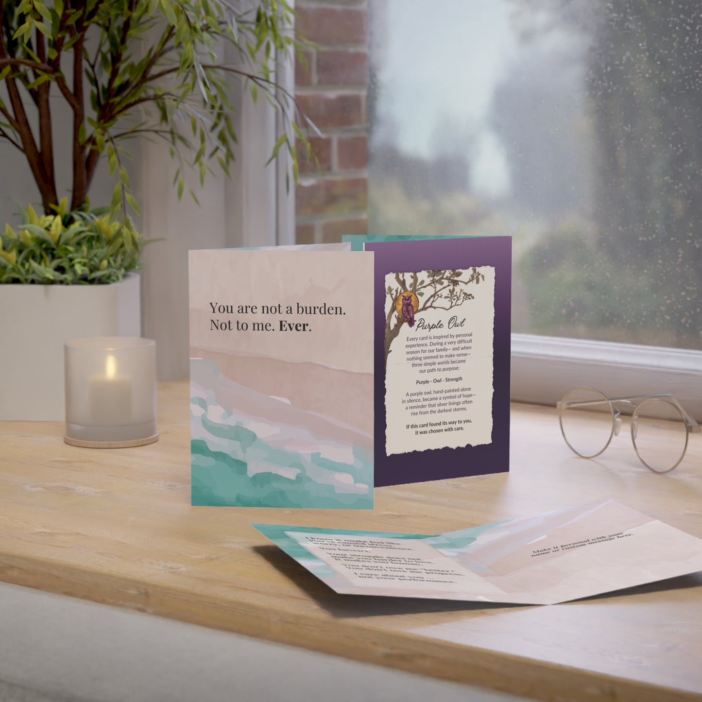 purple owl Greeting cards on a wooden surface with a window and plant in the background