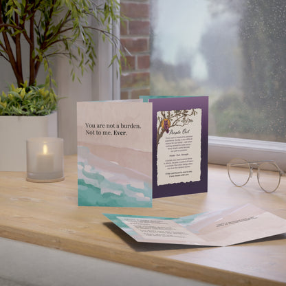 purple owl Greeting cards on a wooden surface with a window and plant in the background
